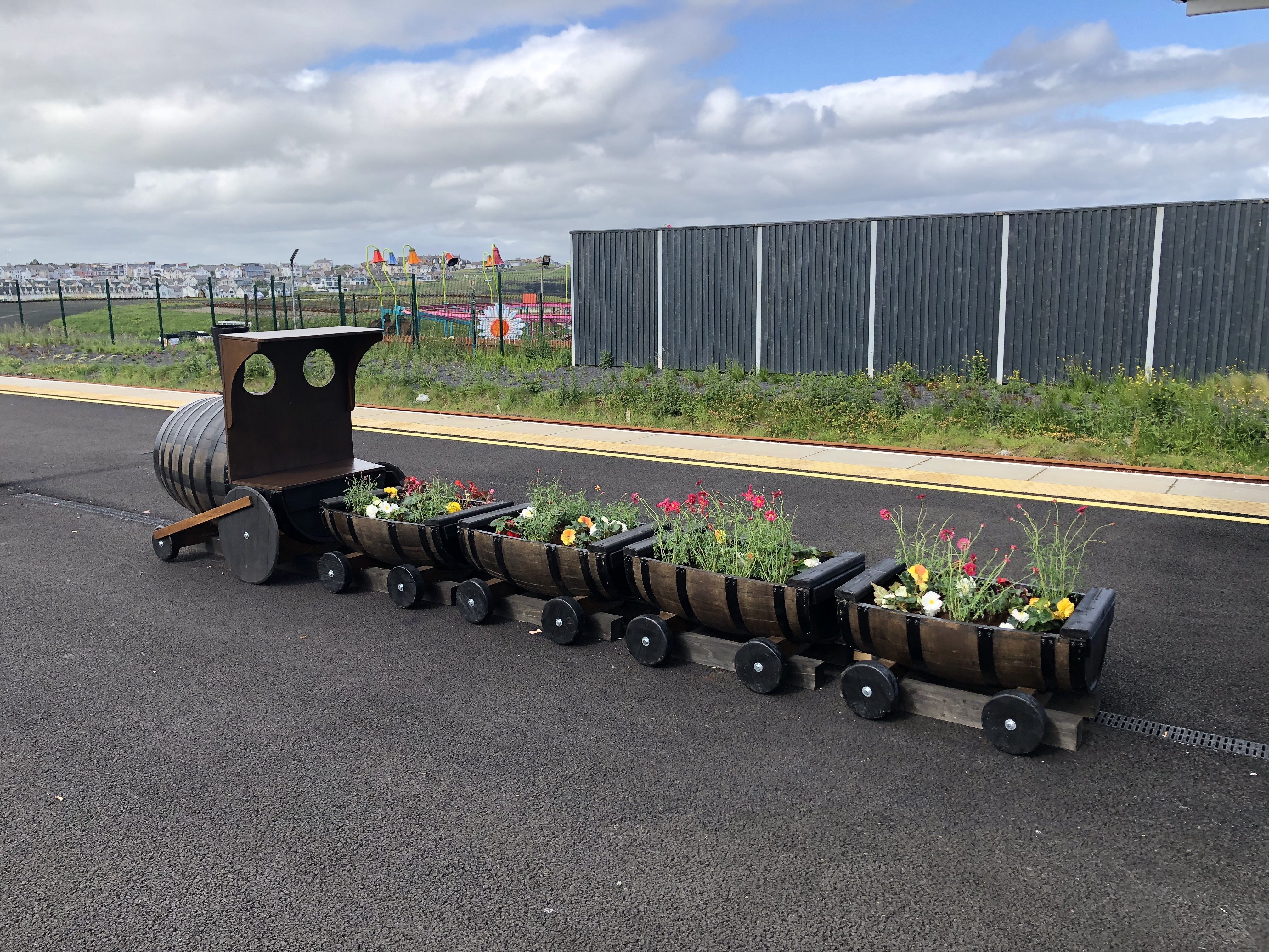 Train barrel planter bursting with blooms halts at Portrush railway station image